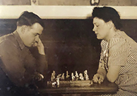 Sepia and white photo of soldier and his wife playing chess with Ellen Jennings chess figures.