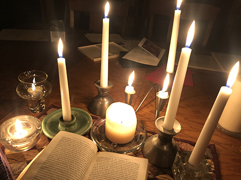 a variety of burning candles illuminating a book