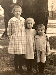 my father with his two older sisters, the eldest with a big bow