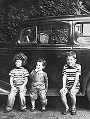 me with my sister and brother sitting on a running board of a classic car