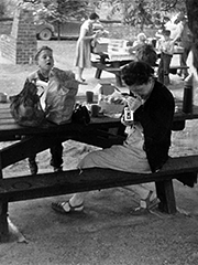 My brother at a picnic table, watching my mother take a photograph