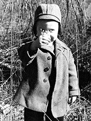 my brother in a sweet jacket and cap, offering flowers