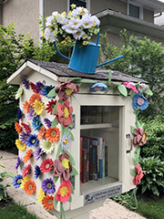 free libary covered with flowers and flower can