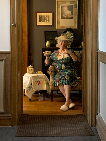 silly lady with tea party set up inside her apartment's front door