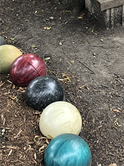 bowling balls laid out in a garden edging a mulched bed
