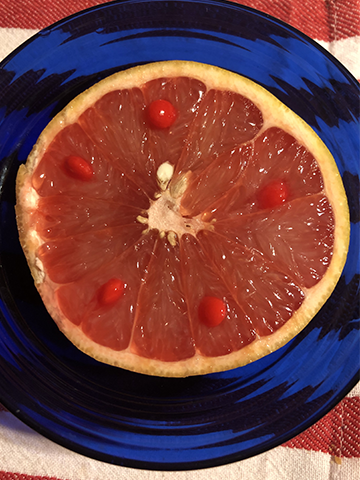 red hot candies on a half red grapefruit