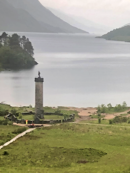 Pillar with sculpture on top by loch
