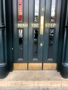 Door with gold lettering "MIND THE STEP"