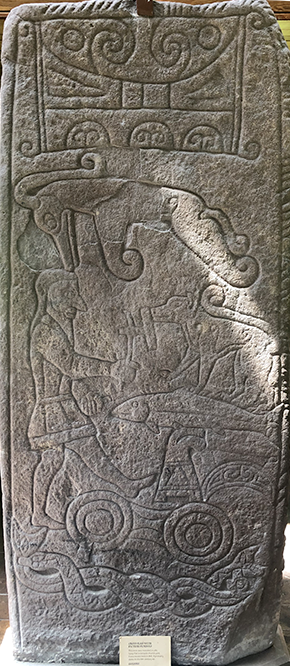 Stone carved with man, fish, wolf, snake, and more