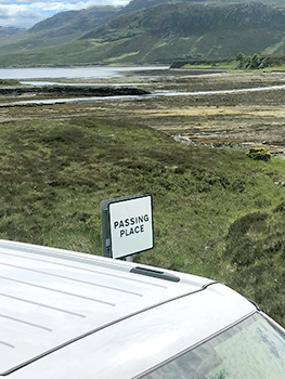 Passing Place sign over car in scene