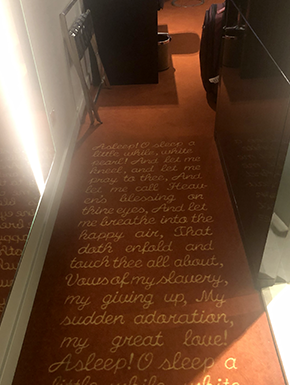 Rug at entry with poem about sleep embedded