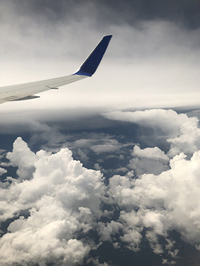 Plane wing above large and varied clouds 