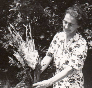 Smiling woman in garden with gladioli