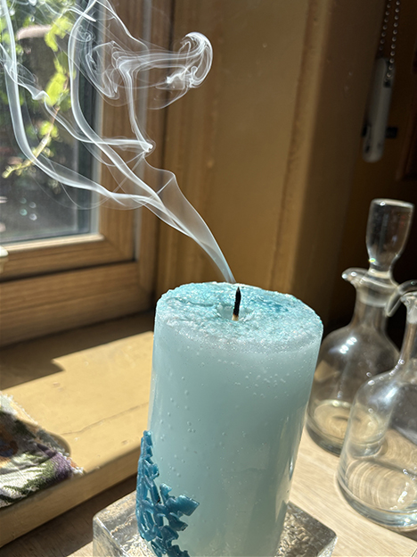 Blue candle extinguished in a sunny kitchen