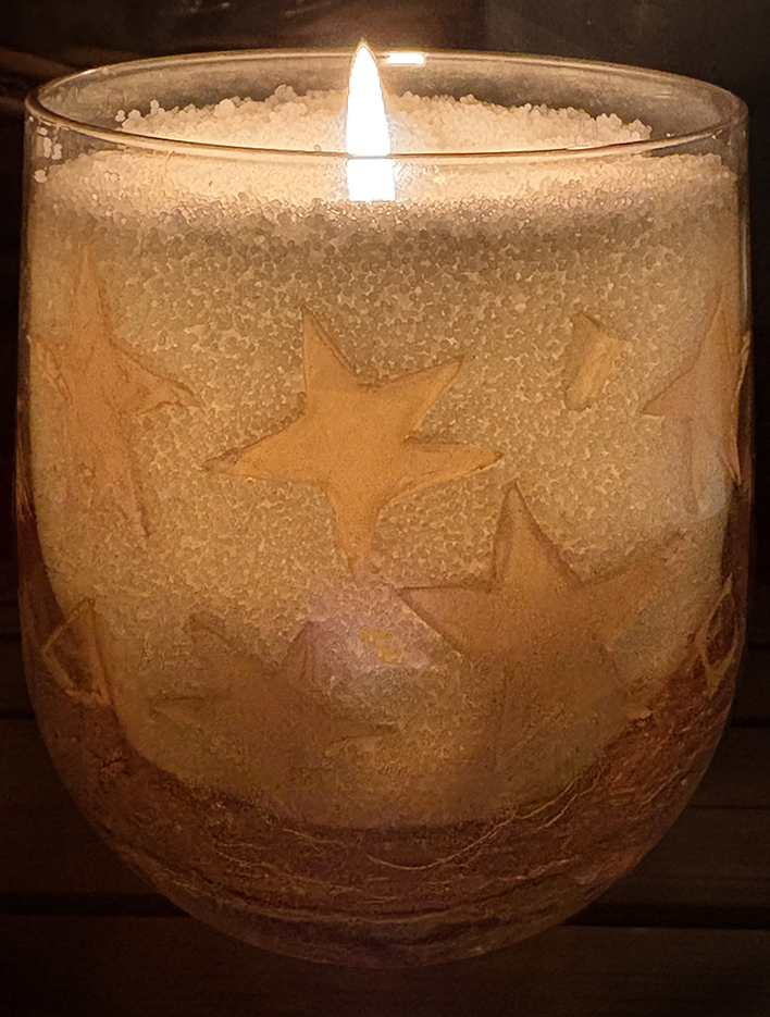 Candle with gold stars in glass